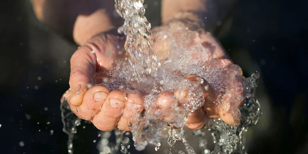 hands washing with water pouring from a tap