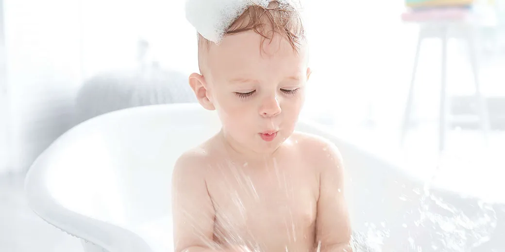 toddler playing in the tub